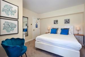 a bedroom with a large bed and a blue chair at Easington Guest House in Banbury