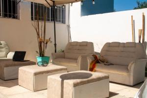 un patio con 2 sofás, 2 sillas y una mesa en Apart Hotel Savona en Capilla del Monte