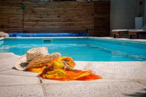 una piscina con un sombrero y un sombrero junto al agua en Apart Hotel Savona en Capilla del Monte