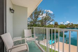 a balcony with chairs and a view of the water at Coconut Bayou home in Anna Maria +19 photos