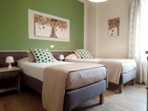 a bedroom with two beds and a chair in it at Art Hotel Pietrasanta in Pietrasanta
