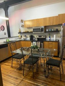 uma cozinha com uma mesa de vidro e cadeiras em Charming 2 bedroom apartment near VCU em Richmond