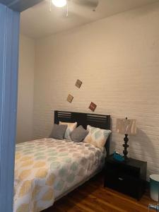 a bedroom with a bed and a table with a lamp at Charming 2 bedroom apartment near VCU in Richmond