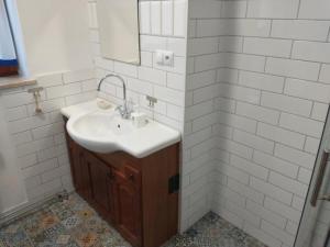 Baño blanco con lavabo y espejo en Apartamenty Zielona Góra, en Zielona Góra