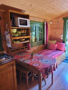 a room with a table and a couch in a cabin at La Roulotte des Oliviers in Saint-Pierre-de-Vassols