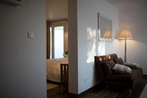 salon z krzesłem i łóżkiem w obiekcie Coin de Charme au Pays Basque w mieście Hasparren