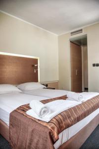 ein Schlafzimmer mit einem großen Bett mit Handtüchern darauf in der Unterkunft Hotel Lent superior in Maribor