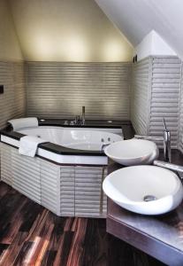 een grote badkamer met 2 wastafels en een bad bij Hotel Lent superior in Maribor