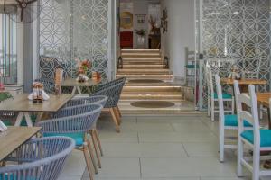 a restaurant with wooden tables and chairs and stairs at W Suites by Estia ex Camelot in Malia