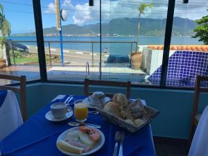 a blue table with a plate of bread and a basket of food at Pousada Irmãos do Mar in Ilhabela