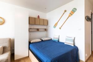 a bedroom with a blue bed with a baseball bat on the wall at La Paradis bleu - Parking privé - Literie confortable - Vue port - Plage à 5 min in La Grande Motte