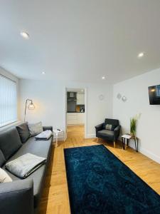 a living room with a couch and a blue rug at Prosper House Apartments in Norwich