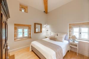 - une chambre avec un lit blanc et 2 fenêtres dans l'établissement Château de Champ-Renard, à Blacé