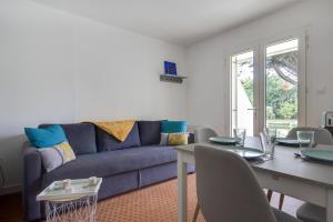 a living room with a blue couch and a table at Le Loriot in Saint-Nic