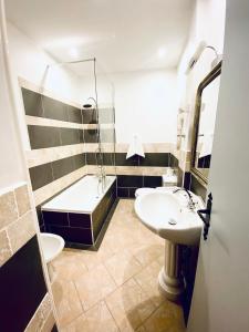 a bathroom with a sink and a toilet and a tub at Château de Fontager in Serves-sur-Rhône