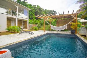 サント・リュスにあるVilla Zen & Calm - Magnifique Villa avec piscineのハンモック付きのスイミングプール、家
