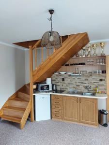 a kitchen with a staircase leading up to a loft at Penzión U Krbu in Habovka