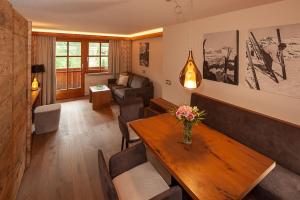 sala de estar con mesa y sofá en Das alpine Lifestyle Berghotel Madlener, en Damüls