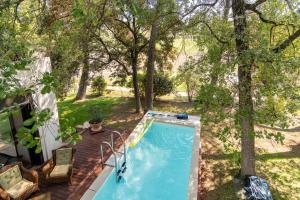 - une vue sur la piscine dans une cour arborée dans l'établissement Villa DaoL - Villa avec piscine et jacuzzi, à Flassans-sur-Issole