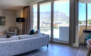 a living room with a couch and a large window at The Capital Mirage in Cape Town