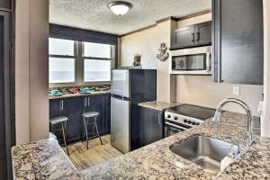 una cocina con electrodomésticos de acero inoxidable y encimeras de granito en Oceanfront Daytona Beach Condo with View, en Daytona Beach