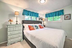 - une chambre avec un lit, une commode et des rideaux bleus dans l'établissement Lakefront Hideaway with Dock, Kayaks, Fire Pit!, 