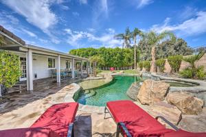 a home with a swimming pool and a patio with chairs at Bermuda Dunes Home with Private Pool and Hot Tub! in Bermuda Dunes