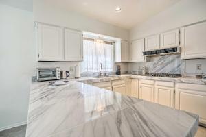 a kitchen with white cabinets and a large marble counter top at Bermuda Dunes Home with Private Pool and Hot Tub! in Bermuda Dunes