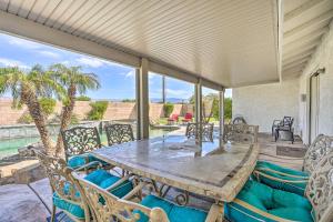 uma mesa e cadeiras num pátio com piscina em Bermuda Dunes Home with Private Pool and Hot Tub! em Bermuda Dunes