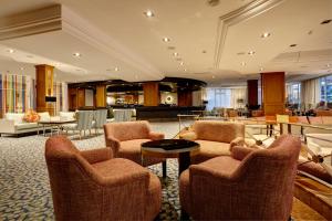 a lobby with chairs and a table in a building at Grupotel Parc Natural & Spa in Playa de Muro