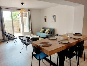 a dining room with a wooden table and chairs at Odos Tarbes Très beau T3 avec petite terrasse et pkg in Odos