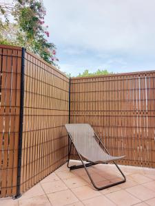 a bench sitting in front of a fence at Odos Tarbes Très beau T3 avec petite terrasse et pkg in Odos