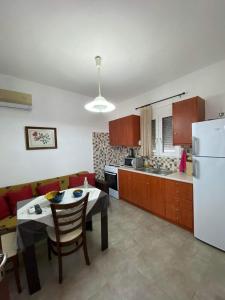 eine Küche und ein Wohnzimmer mit einem Tisch und einem Kühlschrank in der Unterkunft GIANNIS-KLEOPATRA HOUSE 1 in Kerames