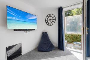 sala de estar con TV de pantalla plana en la pared en River Exe Cottage waterfront, en Exeter