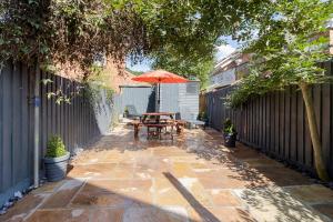 a patio with a table and an umbrella at River Exe Cottage waterfront in Exeter