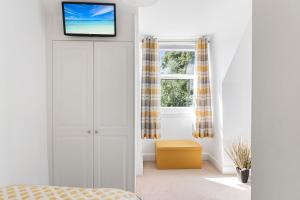 a bedroom with a door with a tv on top at River Exe Cottage waterfront in Exeter