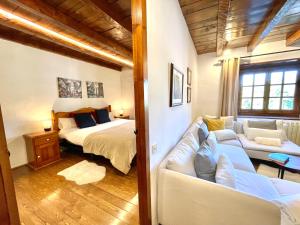 a bedroom with a bed and a couch in a room at Rustic Chic de Luxe 2B in El Tarter