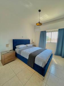 - une chambre avec un lit bleu et des rideaux bleus dans l'établissement Urban Retreat - Your Ideal Getaway in Limassol, à Limassol