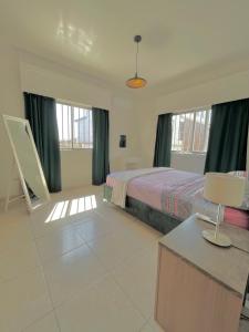 1 dormitorio con 1 cama y 1 mesa con lámpara en Urban Retreat - Your Ideal Getaway in Limassol en Limassol