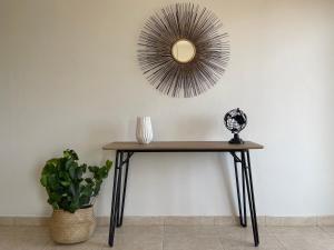 una mesa con un espejo en la pared con una planta en Urban Retreat - Your Ideal Getaway in Limassol en Limassol