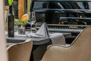 a table with a glass of wine and a piano at Das Stadthaus in Neusiedl am See