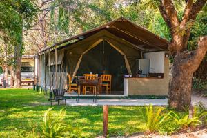 namiot ze stołem i krzesłami na dziedzińcu w obiekcie Zambezi Mubala Camp w Katima Mulilo
