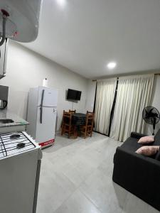 cocina y sala de estar con nevera y sofá en Apart Juncal en Corrientes
