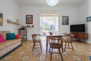 ein Wohnzimmer mit einem Tisch, Stühlen und einem Sofa in der Unterkunft Villa Carlotta Vicino Al Mare in Carini