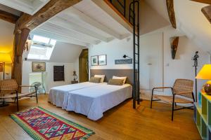 a bedroom with a large bed and two chairs at L'Atelier du Relais in Laives