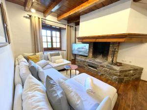 a living room with white couches and a fireplace at Rustic Chic de Luxe 2B in El Tarter