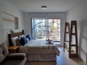 1 dormitorio con cama, escalera y ventana en Dorrego 1829 Studio en Buenos Aires