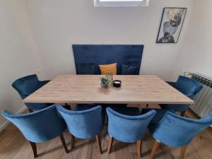 a wooden table with blue chairs around it at Kuća za odmor Maja in Đakovo