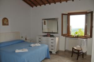 um quarto com uma cama, um espelho e uma janela em Agriturismo Renai e Monte em Gambassi Terme