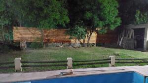 a wooden fence next to a swimming pool at Cabaña con vista al Cerro Arco y la ciudad de Mendoza in Las Heras
